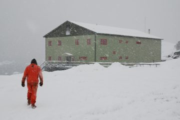 A man walking across a snow covered slope.