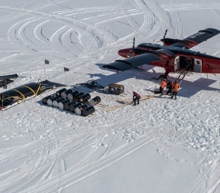 A BAS Twin Otter aircraft loading at a remote field location on the English Coast, Antarctica