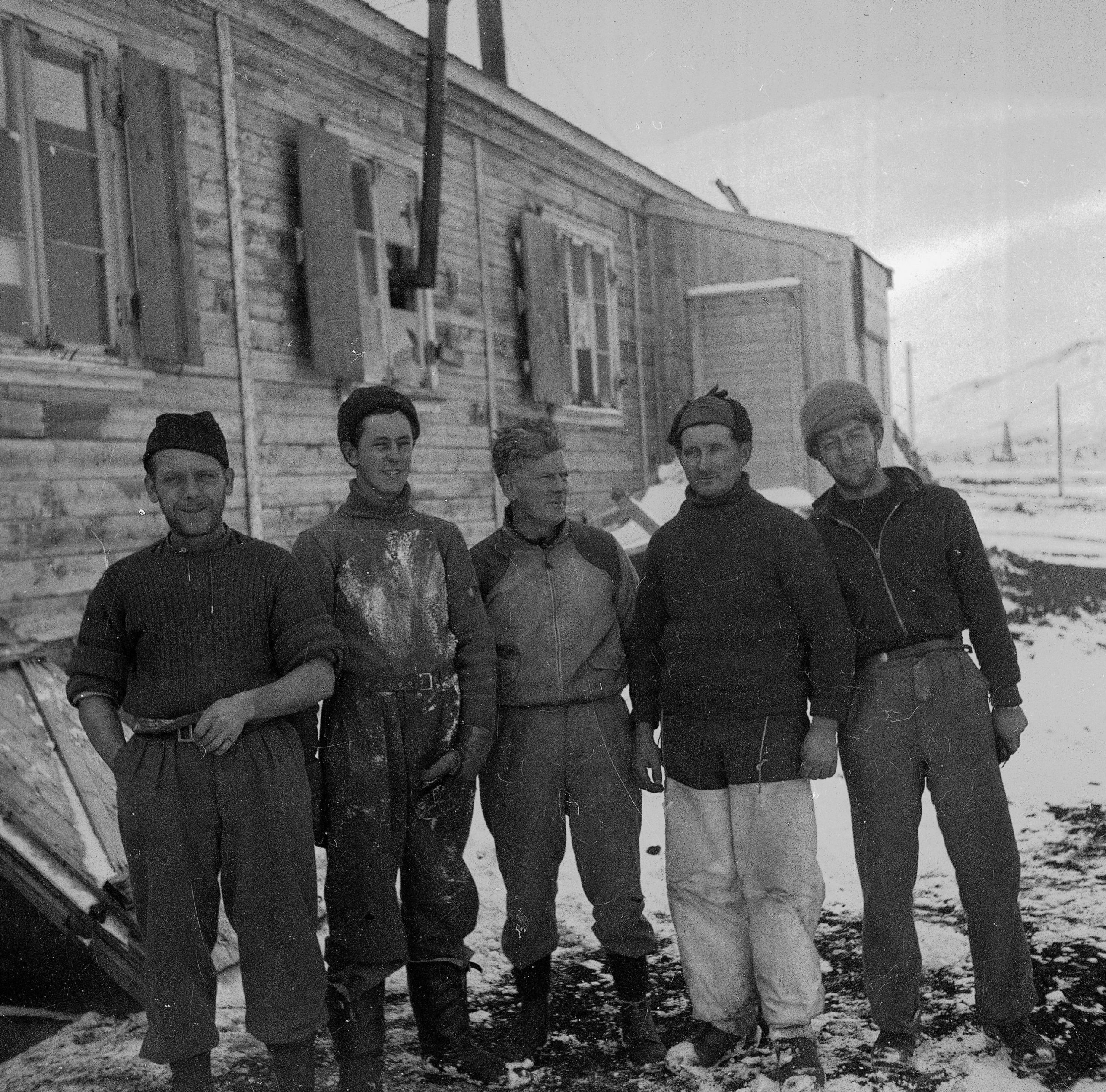 A group of people posing for a photo outside a hut on Deception Island, 1944.