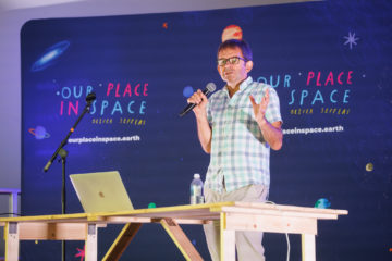 A man standing in front of a sign