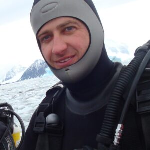 A man wearing a hat and smiling at the camera.