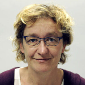 A person wearing glasses and smiling at the camera