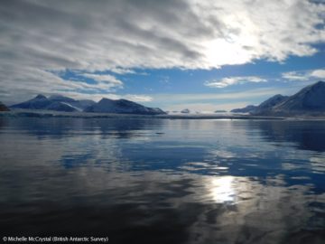 A body of water with a mountain in the background.