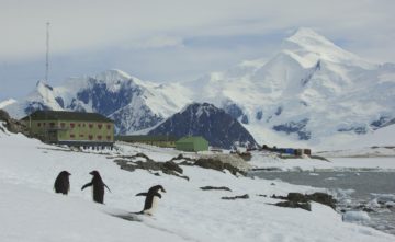 A group of people standing on top of a snow covered mountain.