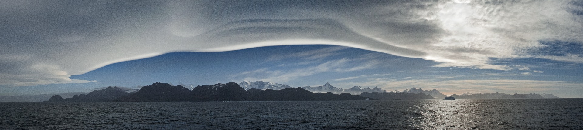 A large body of water with a mountain in the background.