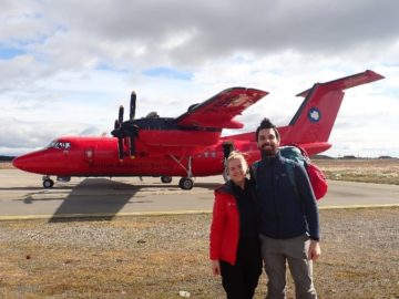 A group of people standing around a plane.