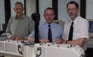 A group of people standing in front of a mirror posing for the camera.
