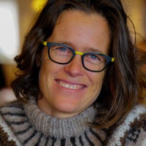 A person wearing glasses and smiling at the camera.