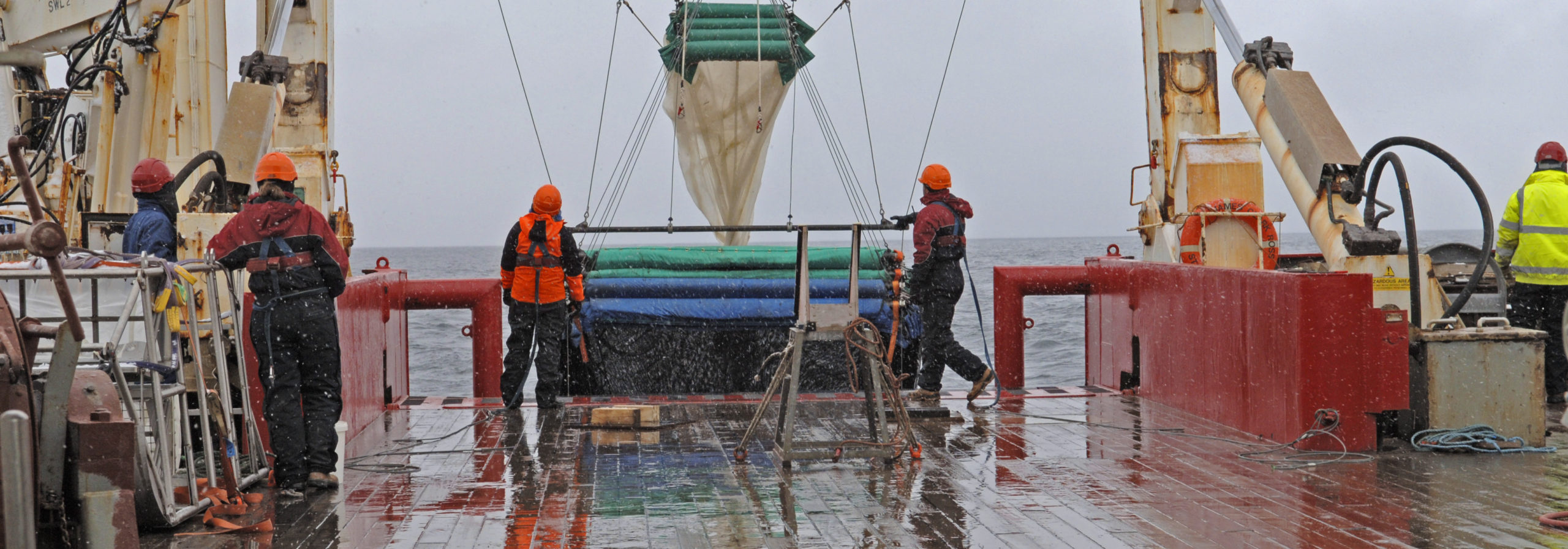 A group of people on a boat in the rain.