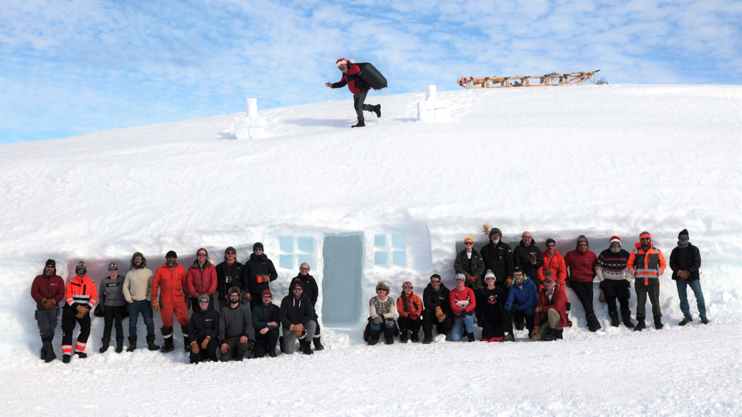 A group of people in front of a structure made from ice