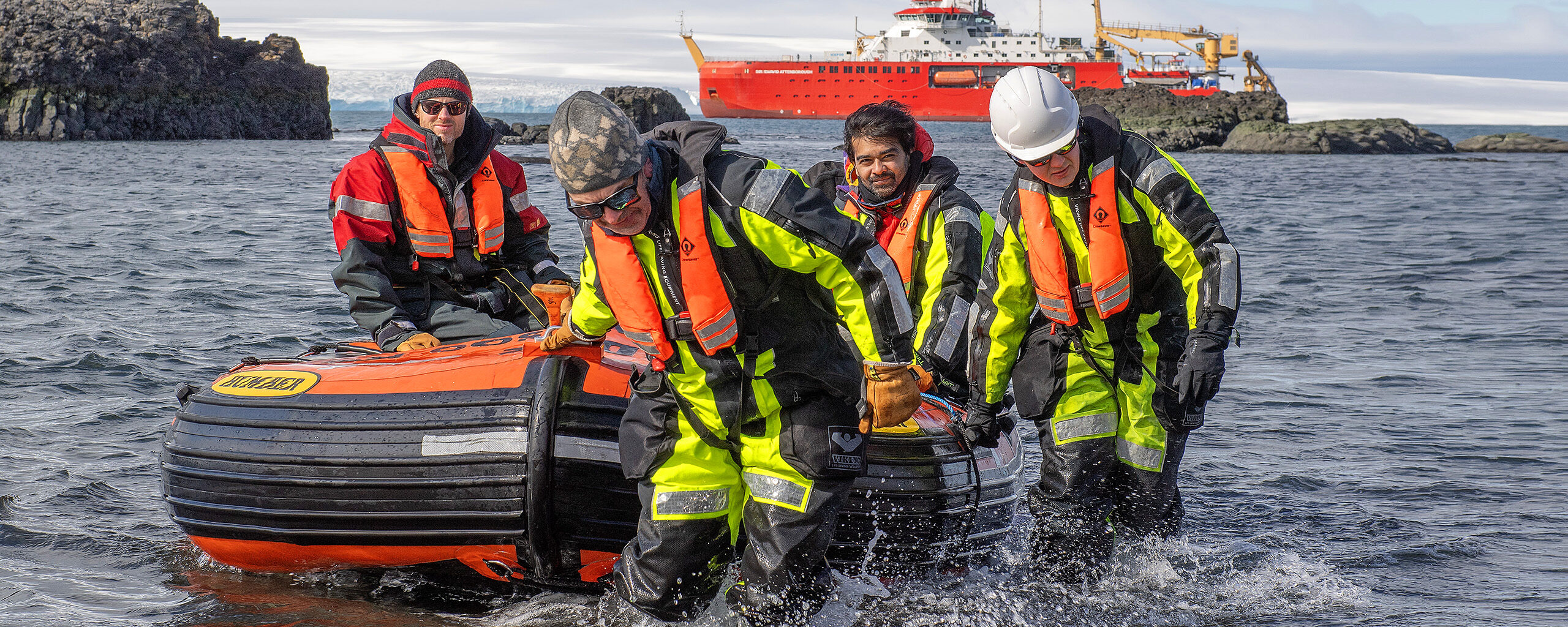 A group of people on a RIB deploying from the RRS Sir David Attenborough