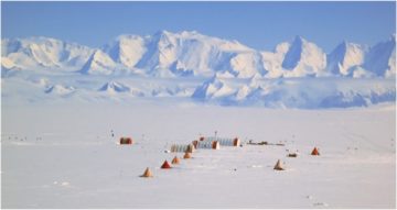 A group of people standing on top of a snow covered mountain.