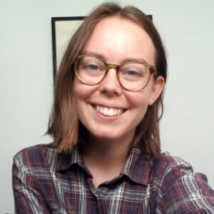 A person wearing glasses and smiling at the camera