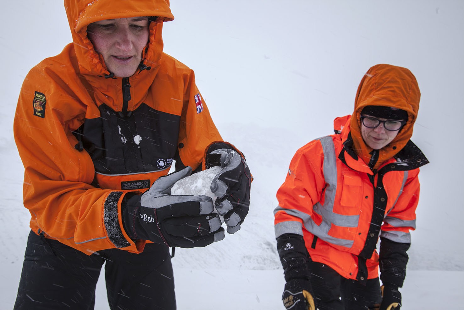 A couple of people that are standing in the snow.