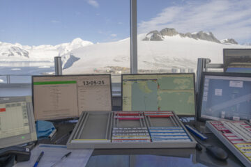 The view from a desk looking out of a window towards a snow capped mountain