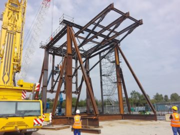 A crane next to a bus.