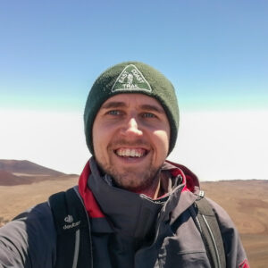 A man wearing a hat and smiling at the camera