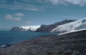 A body of water with a mountain in the background.