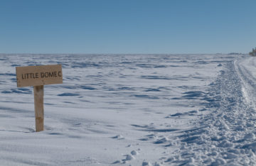 A sign on a pole in the snow
