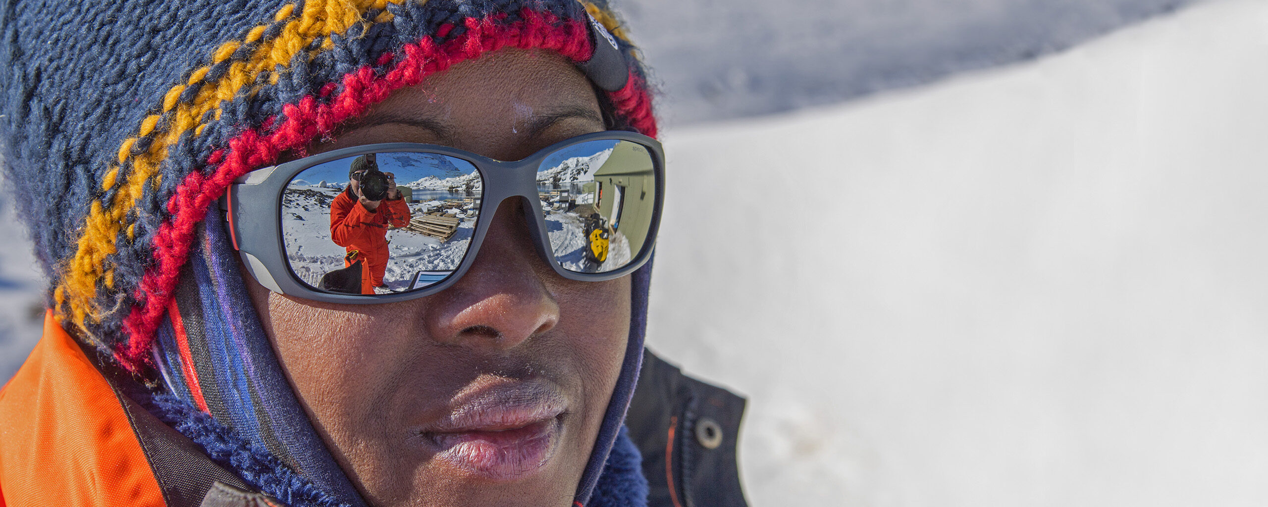 An engineer wearing sunglasses, wolly hat and hi-vis clothing