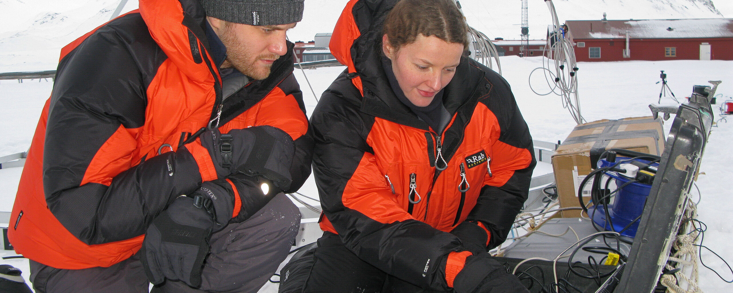 Two scientists working outside in snowy conditions