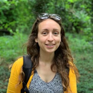 A person standing in front of a forest