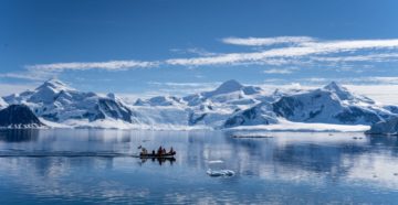 A body of water with a mountain in the snow