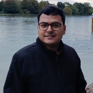 A man posing in front of a body of water