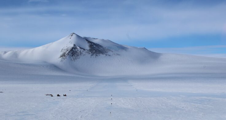 A snow covered mountain and a blue ice runway