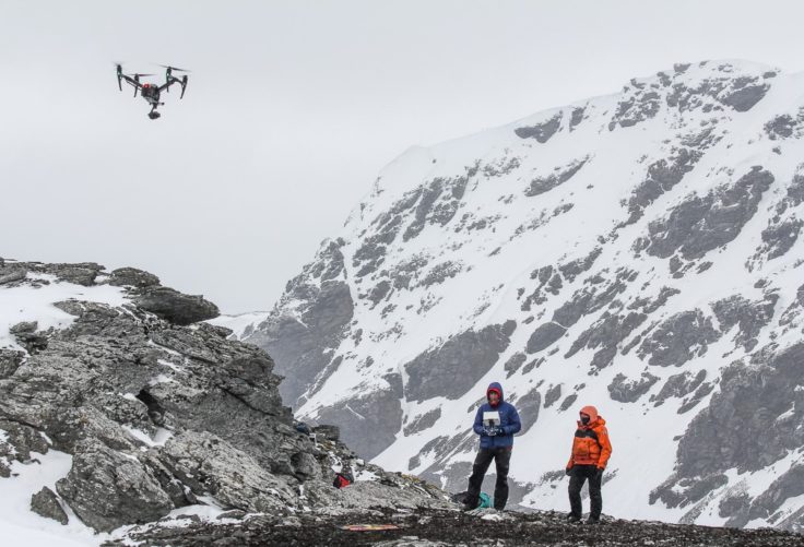 A man standing on top of a snow covered mountain